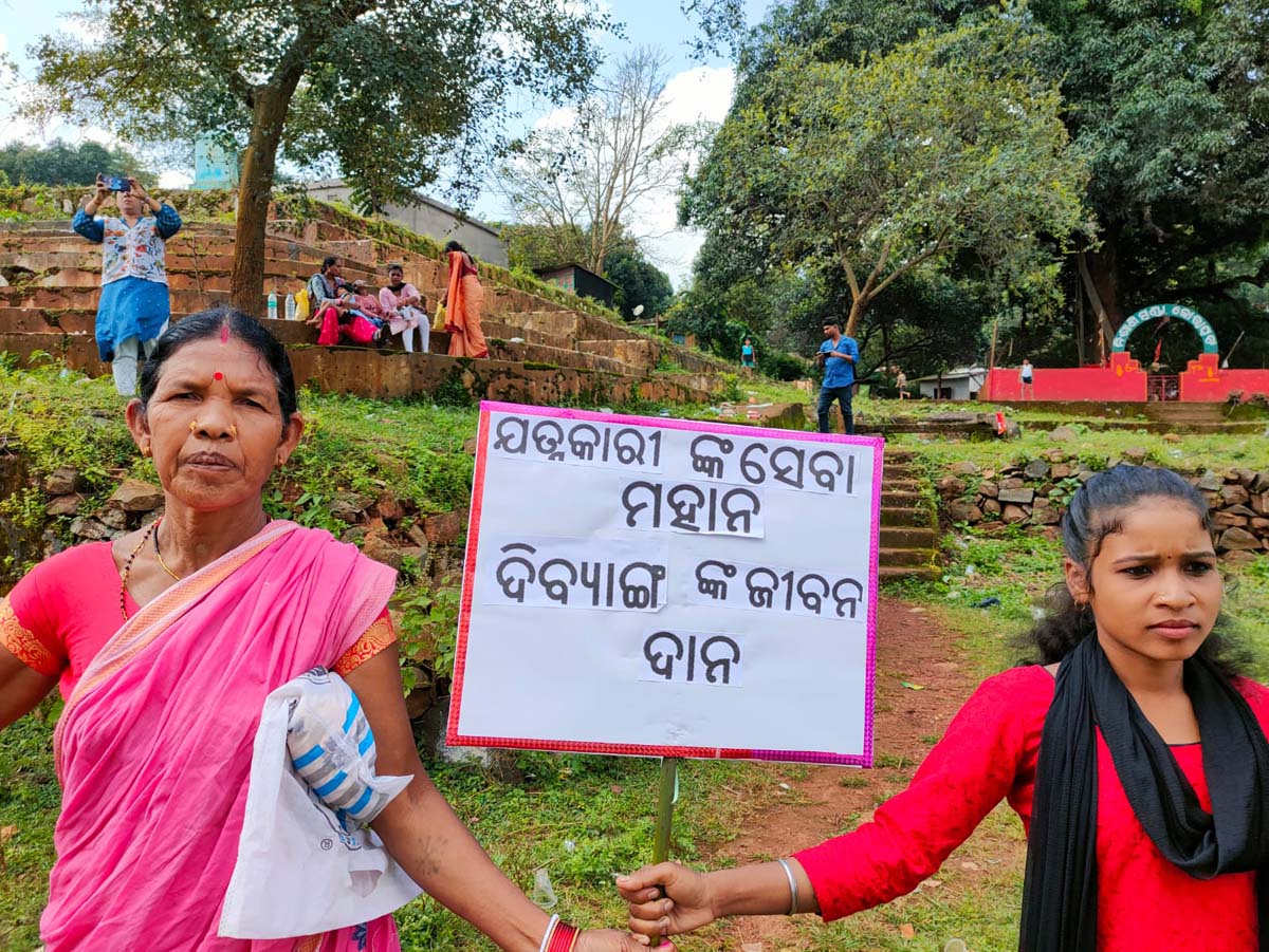 A young woman and her mother holding a sign in India during Carers Day 2023
