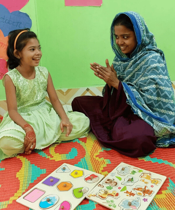 A mother and daughter sitting on the floor playing together