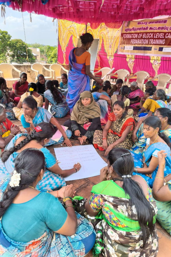 A large group of people sitting on the floor working in small groups