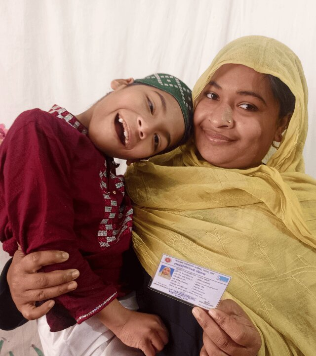 Image of a woman holding up an ID card with her arm around her child