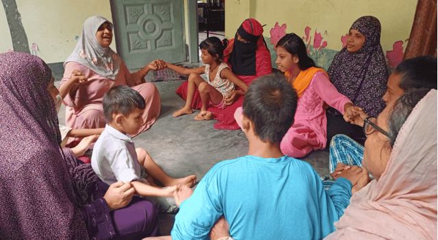 Group of women and sitting in a circle with their children sitting on their laps