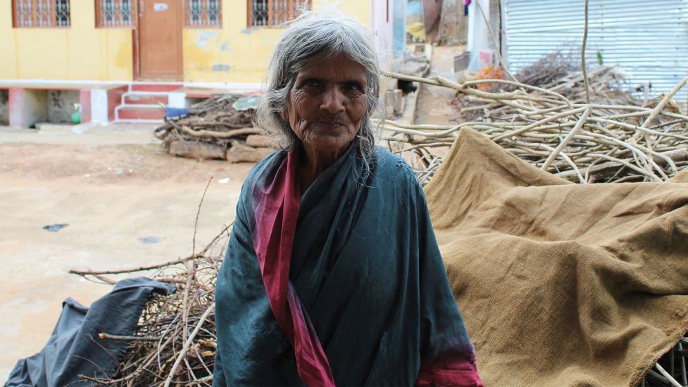 Elderly carer stood outside in India