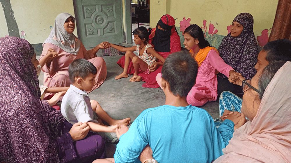 Group of women and sitting in a circle with their children sitting on their laps