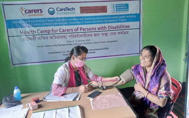 Doctor conducting health check on female carer in Bangladesh