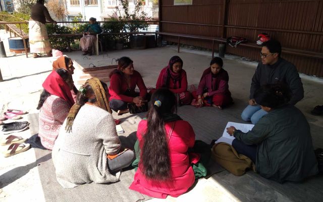 A group of people sitting in a circle in a counselling meeting in Nepal.